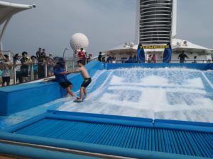 L concentrating on his balancing at the Flow Rider (Voyager of the Seas, Royal Caribbean Cruise)